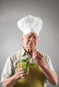 Elderly Man wearing Chef's Hat holding Basil