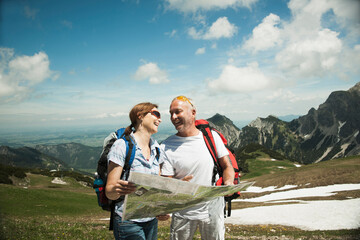 Mature couple looking at map, hiking in mountains, Tannheim Valley, Austria
