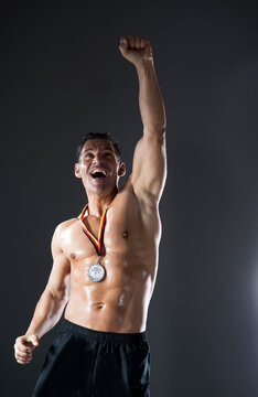 Muscular Man with Medal around Neck Cheering, Studio Shot