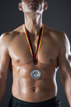 Close-up of Muscular Man with Medal around Neck, Studio Shot