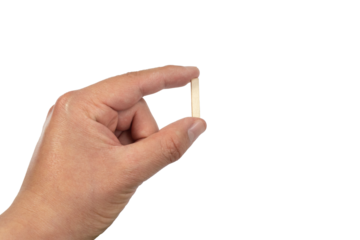 Close up of a person's hand holding a small wooden letter I isolated on a white background