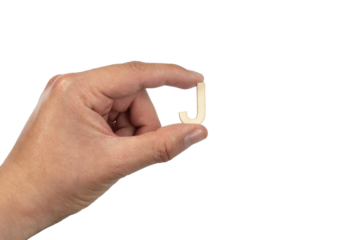 Close up of a person's hand holding a small wooden letter J isolated on a white background