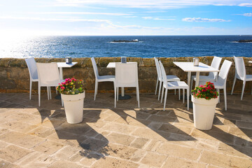 Cityscape of a cafe terrace by the seaside in Gallipoli. Architecture of Gallipoli in Apulia, Italy, Europe