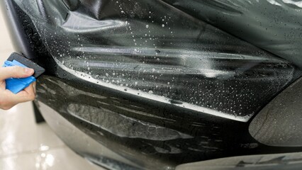 Protective film for car body. Overlaying a vinyl film on the surface of body parts. Vehicle detailing.