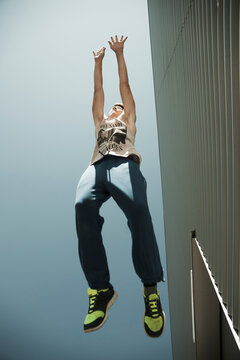 Low angle view of teenager jumping in midair, freerunning, Germany