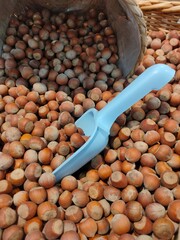 brown hazelnuts poured into a basket on the supermarket counter
