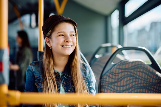 Happy little girl enjoys the ride in public bus.