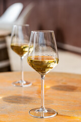 Two glasses of white wine on a table.