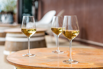 Three glasses of white wine set out on a table.