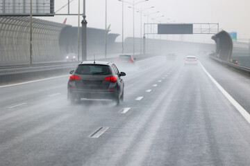 Samochody na drodze w czsie padającego deszczu. Ślisko. 