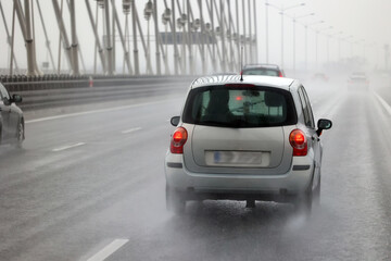 Samochody na drodze w czsie padającego deszczu. Ślisko.  - obrazy, fototapety, plakaty