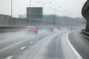 Samochody na drodze w czsie padającego deszczu. Ślisko. 