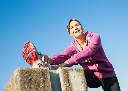 Mature Woman Stretching Outdoors, Mannheim, Baden-Wurttemberg, Germany
