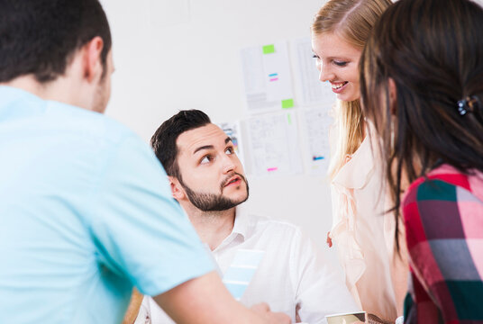 Close-up of group of young business people meeting and in discussion in office, Germany