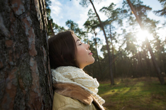 Young Woman Leaning against Tree Trunk, Mannheim, Baden-Wurttemberg, Germany