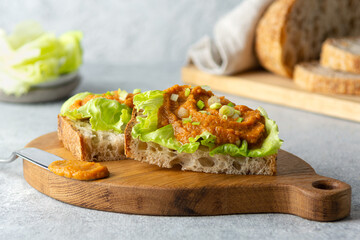 Toasted bread bruschetta with zucchini vegetable caviar, lettuce and green onions, on a wooden board. Healthy diet food concept. Close-up.