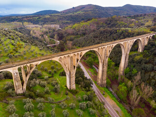 Scenic drone view of green spring hilly landscape with Guadalupe viaduct built in early 20th century, planned as railway bridge, Spain.. - obrazy, fototapety, plakaty