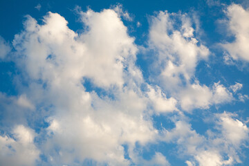 Naklejka na ściany i meble Scattered white fluffy clouds in blue sky