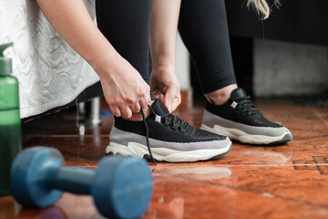 detailed shot of a woman tying her shoelaces before going out for a workout