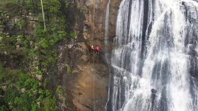Aerial view of couple abseiling in a huge waterfall, Minas Gerais, Brazil