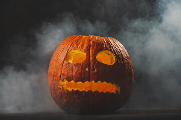 Fototapeta premium Halloween Jack-O-Lantern carved pumpkin with smoke coming out of it