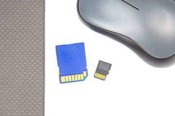 sd memory card for recording electronic data near a laptop on a white background. electronic...