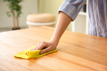 Woman cleaning table in room, closeup