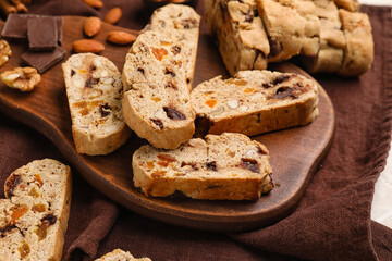 Wooden board with tasty biscotti cookies on table, closeup