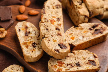 Wooden board with tasty biscotti cookies on table, closeup
