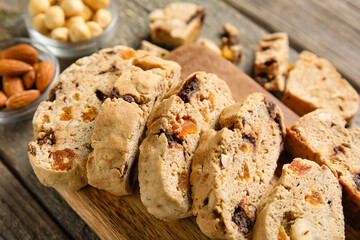 Board with delicious biscotti cookies on wooden background