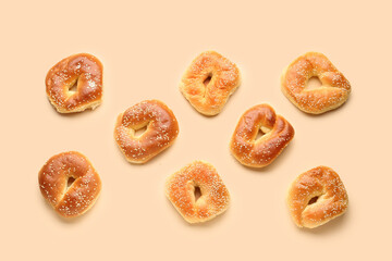 Tasty bagels with sesame seeds on beige background