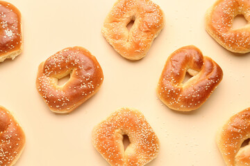 Tasty bagels with sesame seeds on beige background