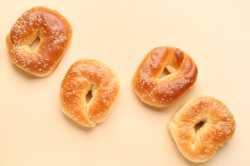 Tasty bagels with sesame seeds on beige background