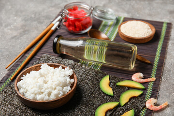 Different ingredients for preparing tasty sushi rolls with rice vinegar on grunge background, closeup