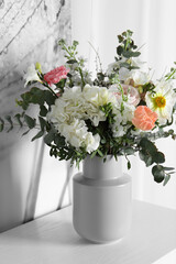 Bouquet of beautiful flowers on white table indoors