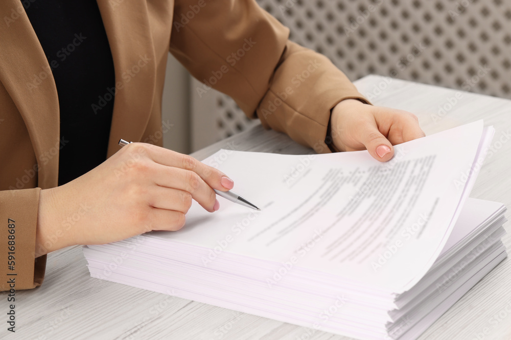 Wall mural Woman signing document at wooden table, closeup