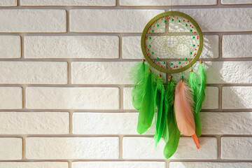 Dream catcher hanging on white brick wall