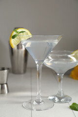 Glasses of martini with lemon on tile table