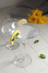 Glasses of martini with lemon on tile table