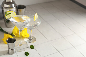 Glasses of martini with lemon on tile table
