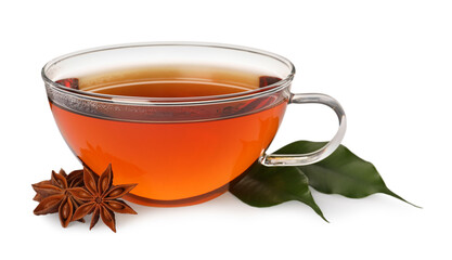 Glass cup of hot tea with anise stars and green leaves on white background