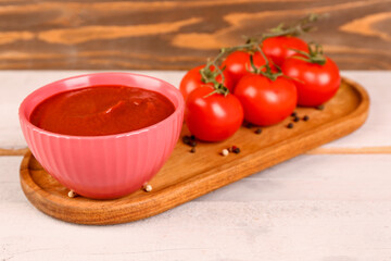Bowl with tasty tomato paste on table