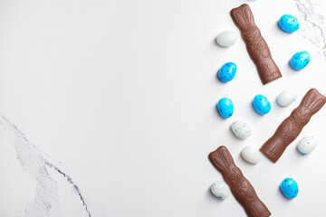 Chocolate bunnies and Easter eggs on white marble table