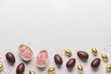 Chocolate Easter eggs and sprinkles on white background