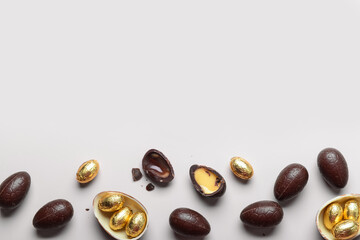 Sweet chocolate Easter eggs and candies on light background