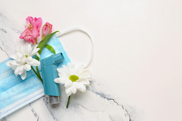 Asthma inhaler with flowers and medical mask on grunge background