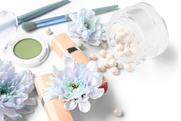 Obraz na płótnie Canvas Decorative cosmetics with brushes and flowers on white background, closeup