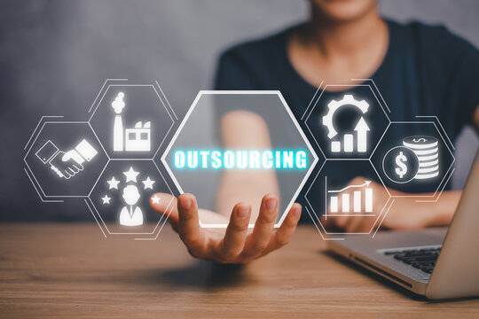 Outsourcing Global Recruitment Business and internet concept, Business person hand holding outsourcing icon on virtual screen with blue bokeh background.