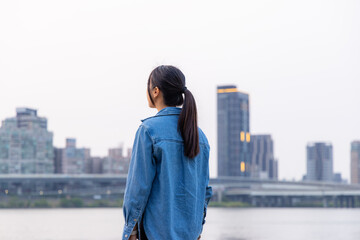 Fototapeta na wymiar Woman look at the view in riverside of Taipei city