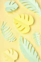 Composition with paper tropical leaves on yellow background